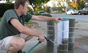 man cleaning pool filters