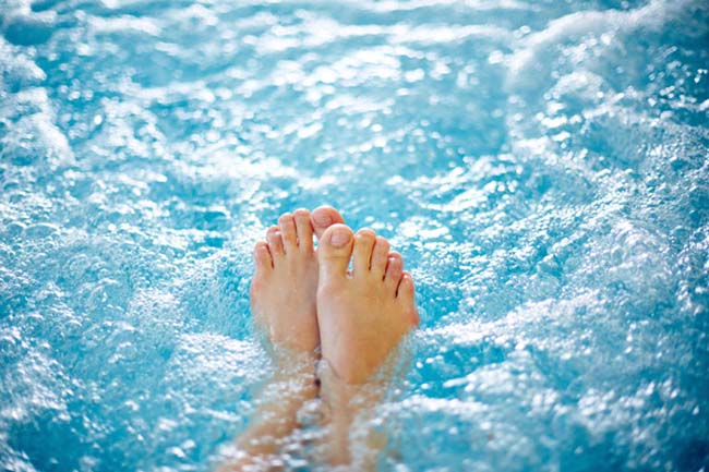close up of feet floating in pool